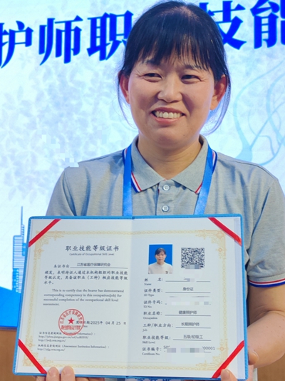 4月28日，長期照護(hù)師代表展示自己的“000001”編號(hào)證書。攝影/郭晉暉
